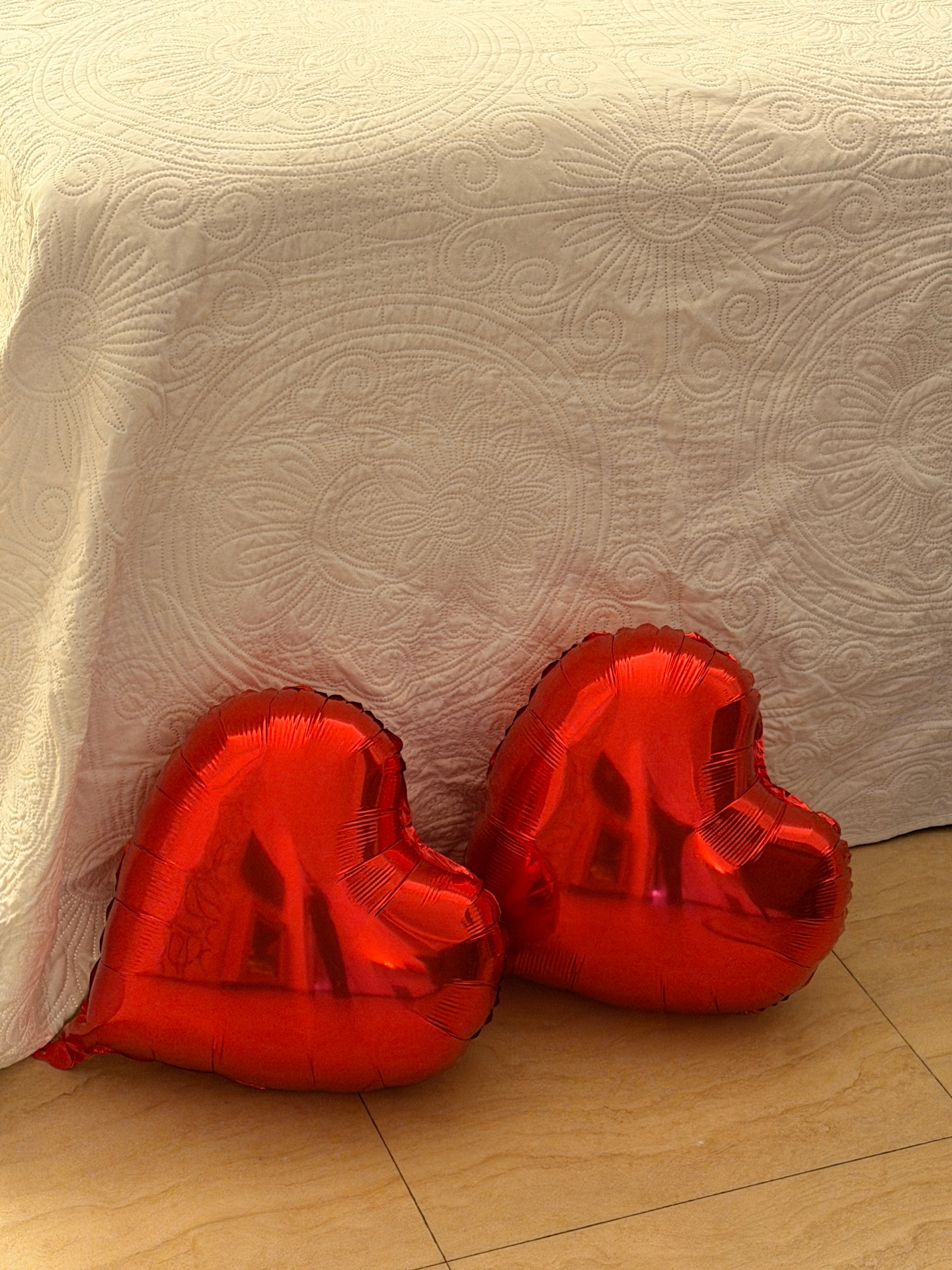 Rote Herzluftballons als liebevolles Detail am Bett