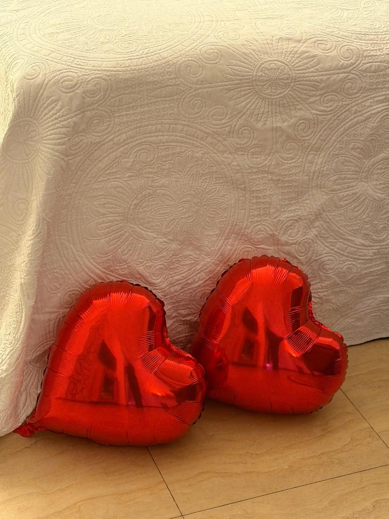 Rote Herzluftballons als liebevolles Detail am Bett