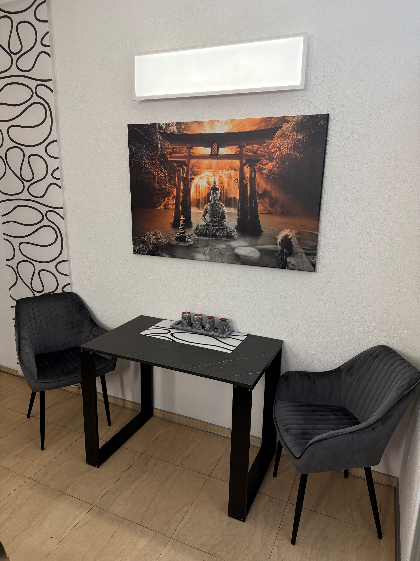 Stilvoller Sitzbereich mit Tisch und Buddha-Wandbild